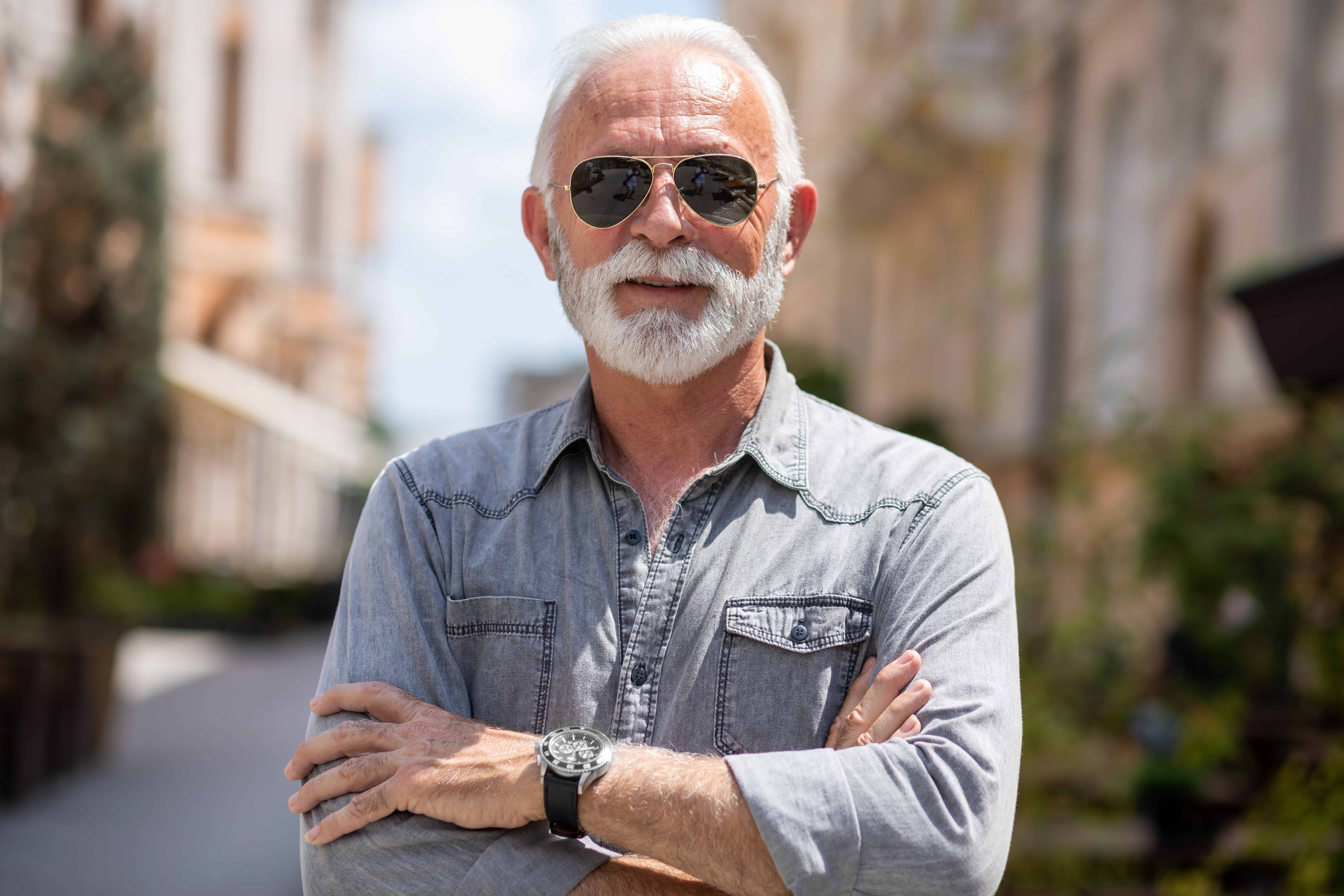 Old rich man with sun glasses and beard on street portrait